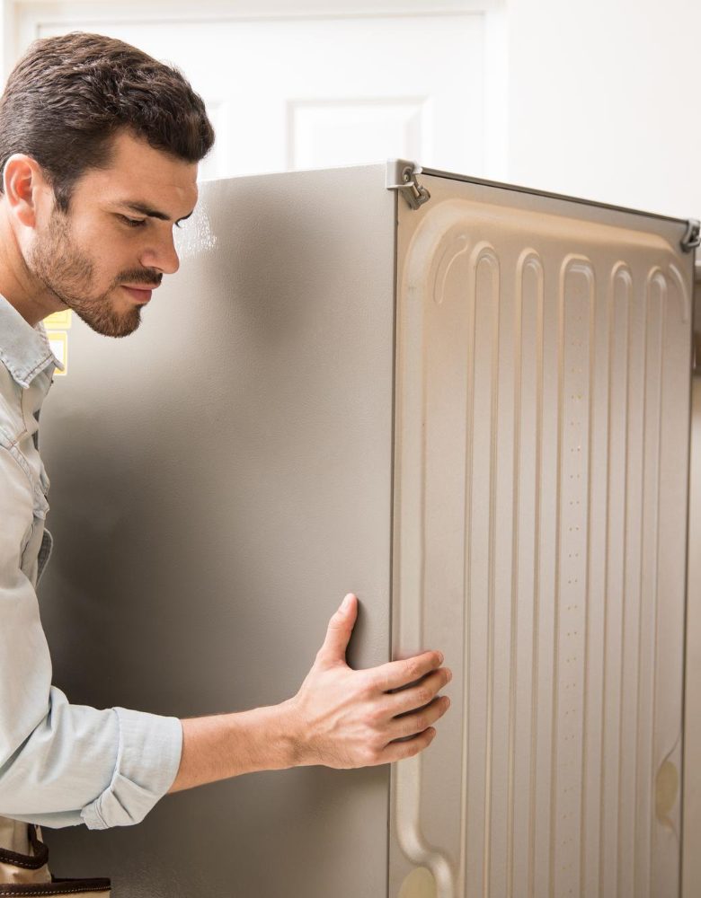 young-man-working-as-electrician-exposing-back-fridge-check-repair-it